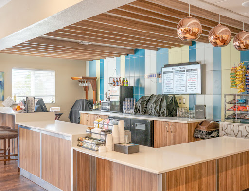 A modern coffee shop interior featuring a stylish barista counter with wooden accents and contemporary lighting.