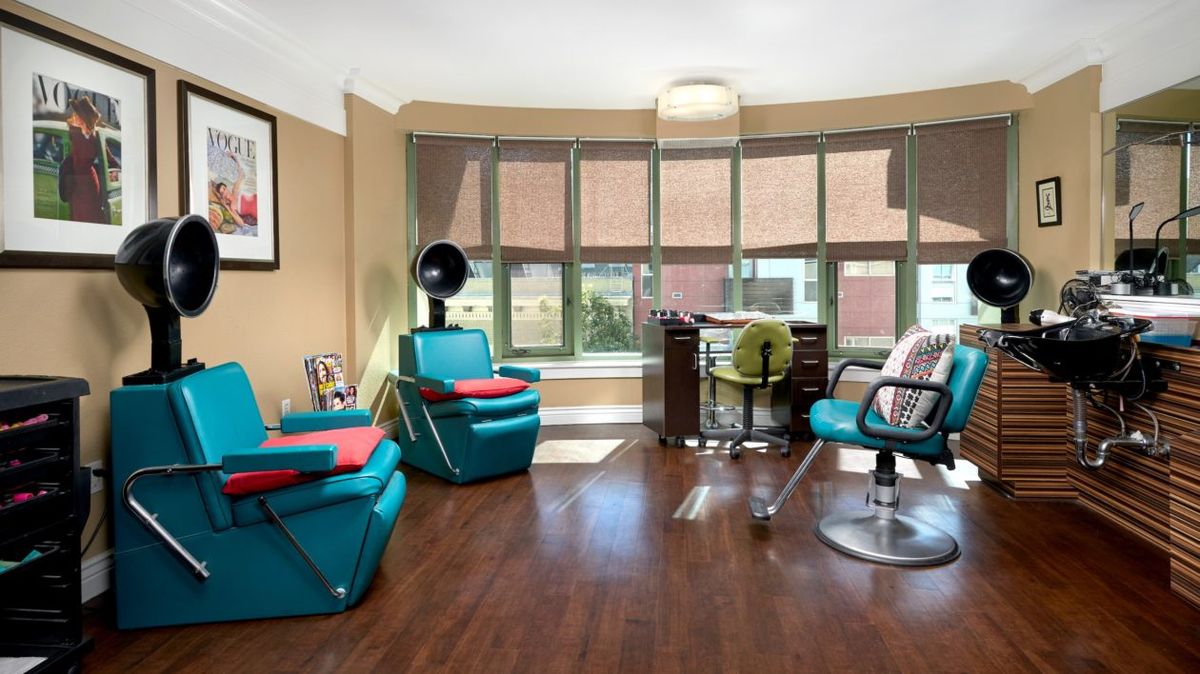 A modern hair salon with styling chairs and large windows.