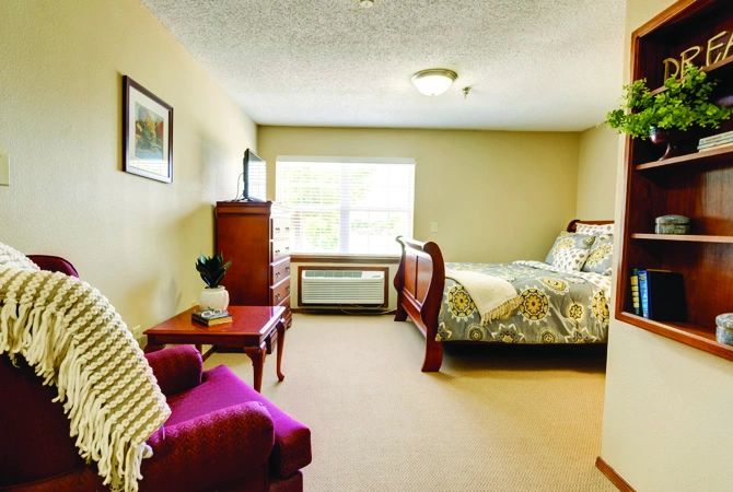 A cozy and well-furnished bedroom with a large window and stylish decor.