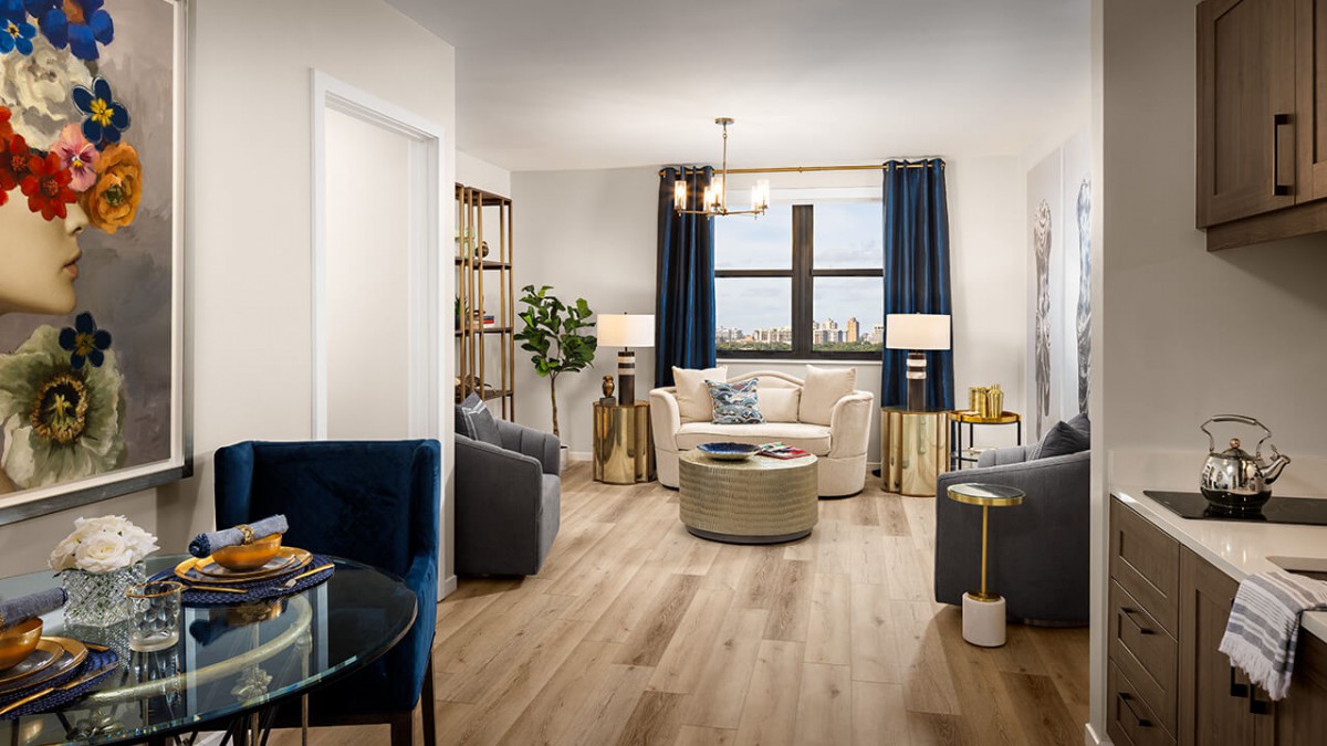 A modern living room with stylish furnishings, featuring a large window and wooden flooring.
