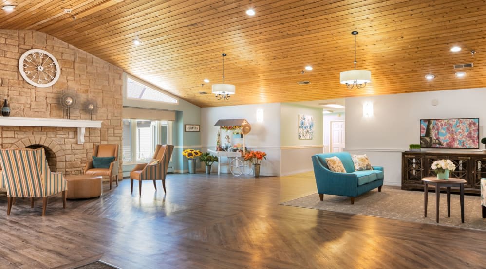 A spacious and elegantly designed living room with a wooden ceiling, modern furniture, and ample natural lighting.