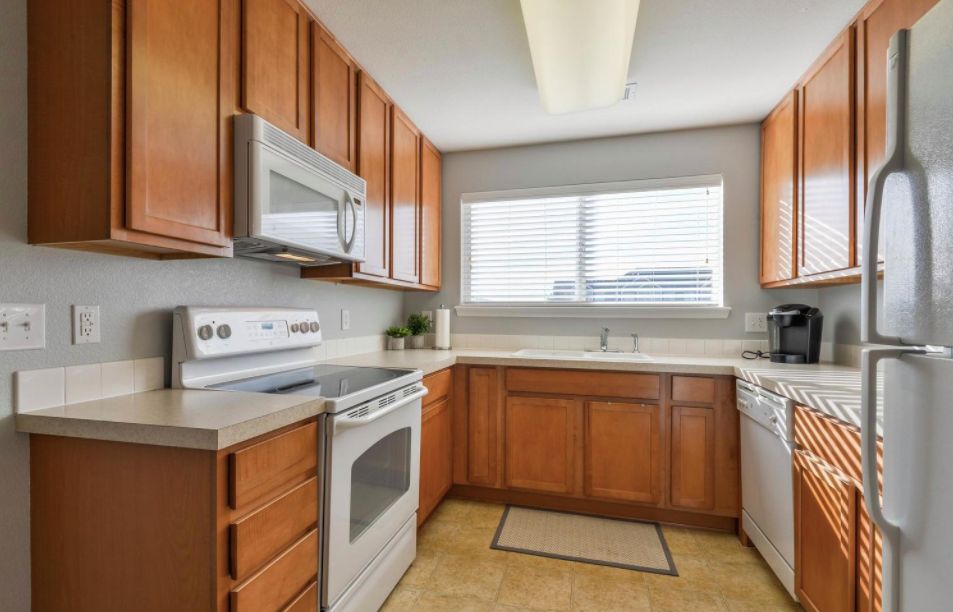 A modern kitchen with wood cabinets and stainless steel appliances.