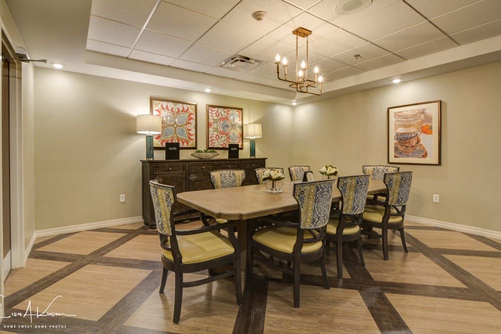 A well-designed dining room with a large table and chairs, elegant lighting, and artwork on the walls.