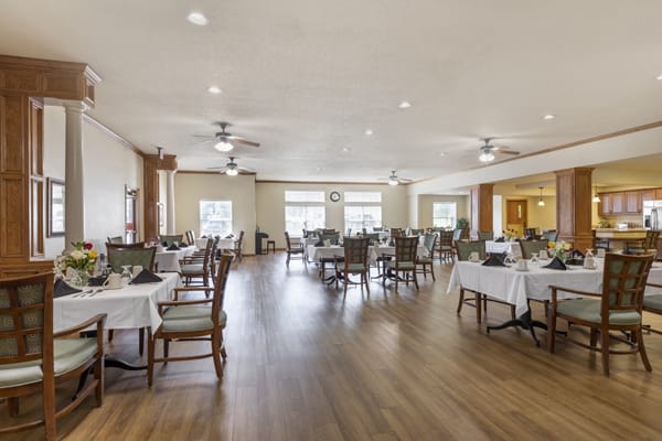 An empty dining room with neatly arranged tables and chairs, featuring a spacious and well-lit interior.