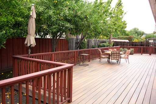 A serene outdoor deck area surrounded by lush greenery and comfortable seating.