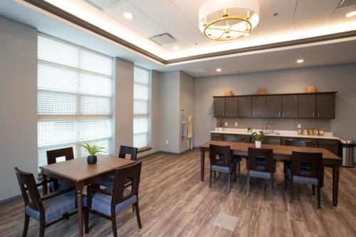 A modern meeting room with a kitchenette and stylish furniture.