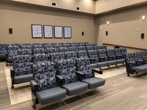 A modern auditorium seating area with patterned chairs and a warm color palette.