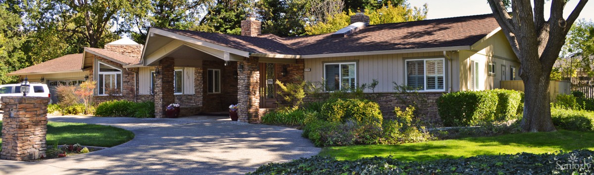 A charming single-story house with a garden and driveway.