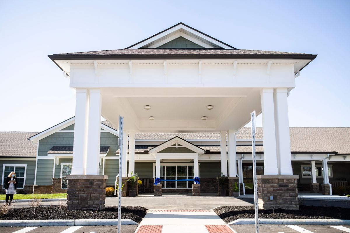 The entrance of a modern building with a large canopy and columns.