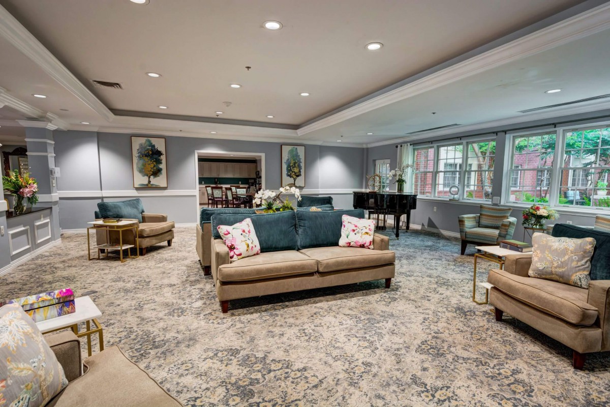 A cozy living room with comfortable sofas, a piano, and stylish decor.