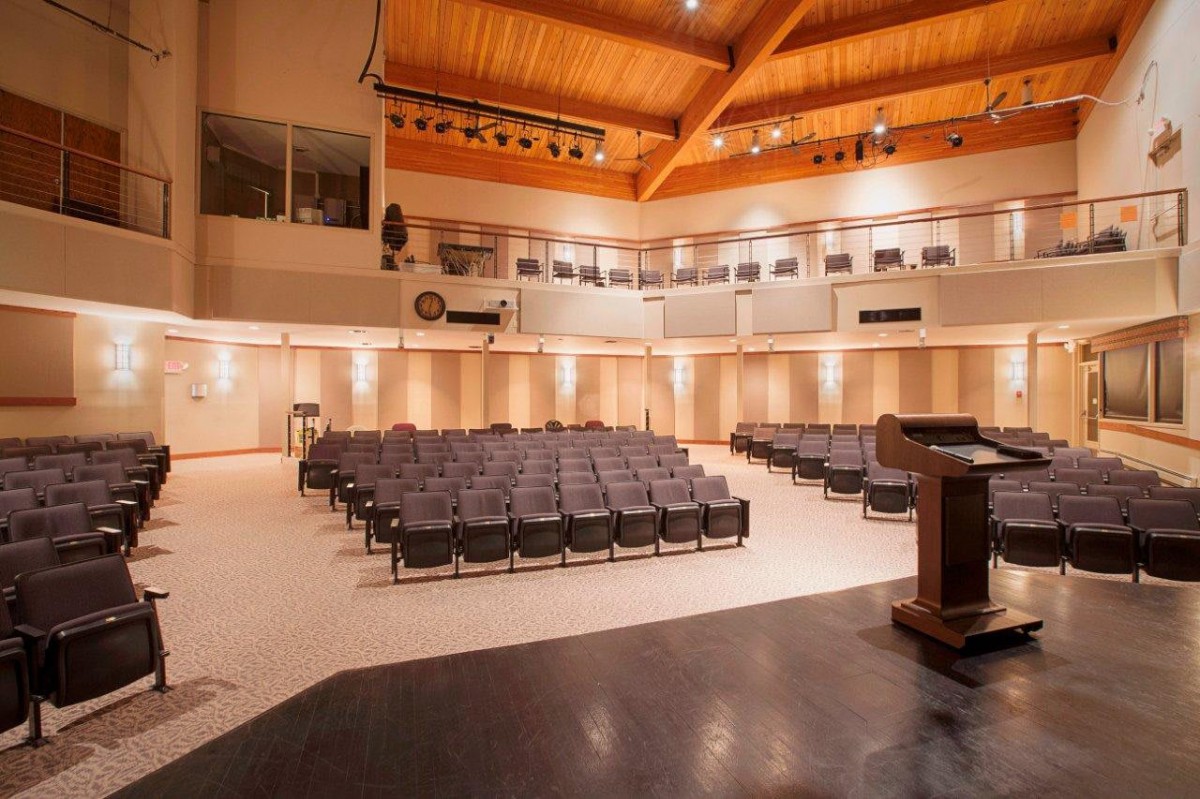 An empty auditorium with rows of seating and a stage area.