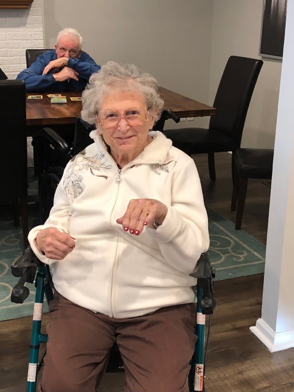 An elderly woman sitting in a wheelchair indoors.