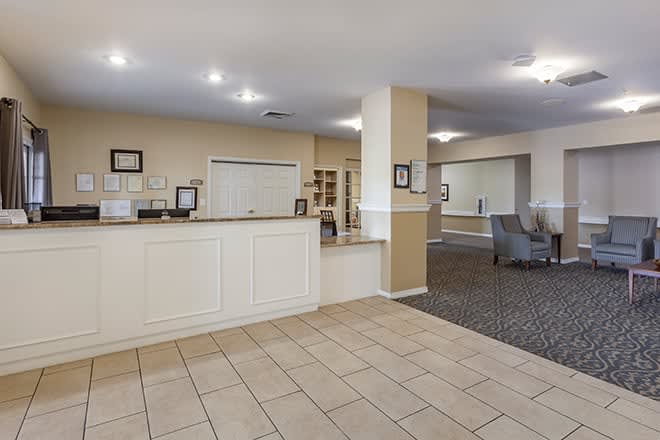 A spacious hotel lobby with a reception desk and seating area.