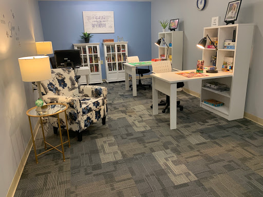 A well-organized modern office space featuring a workspace with desks, lamps, and decorative elements.