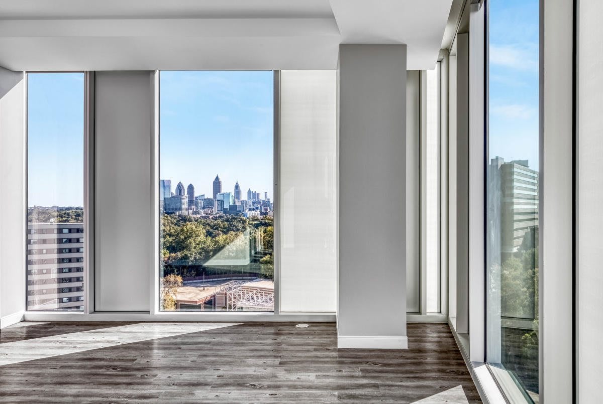 A modern apartment with large panoramic windows offering a stunning city view.