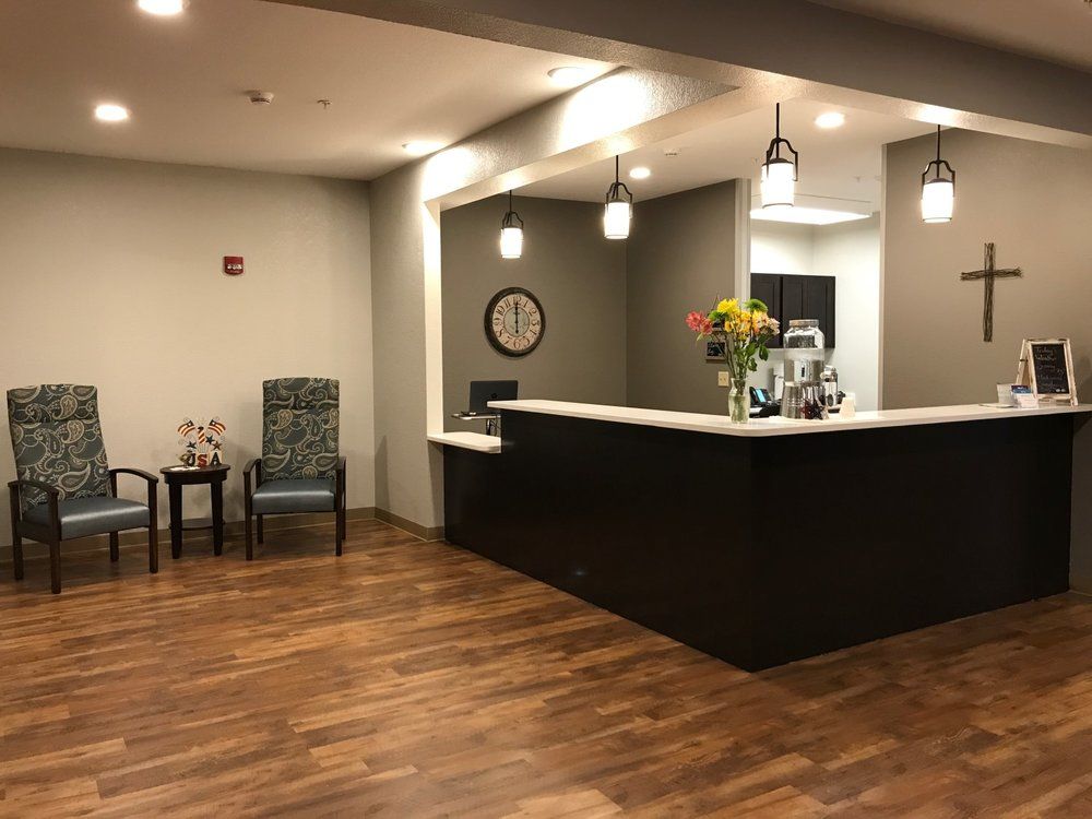 A modern reception area with a wooden floor and a stylish desk.