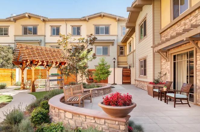 A picturesque courtyard featuring outdoor seating and vibrant landscaping.