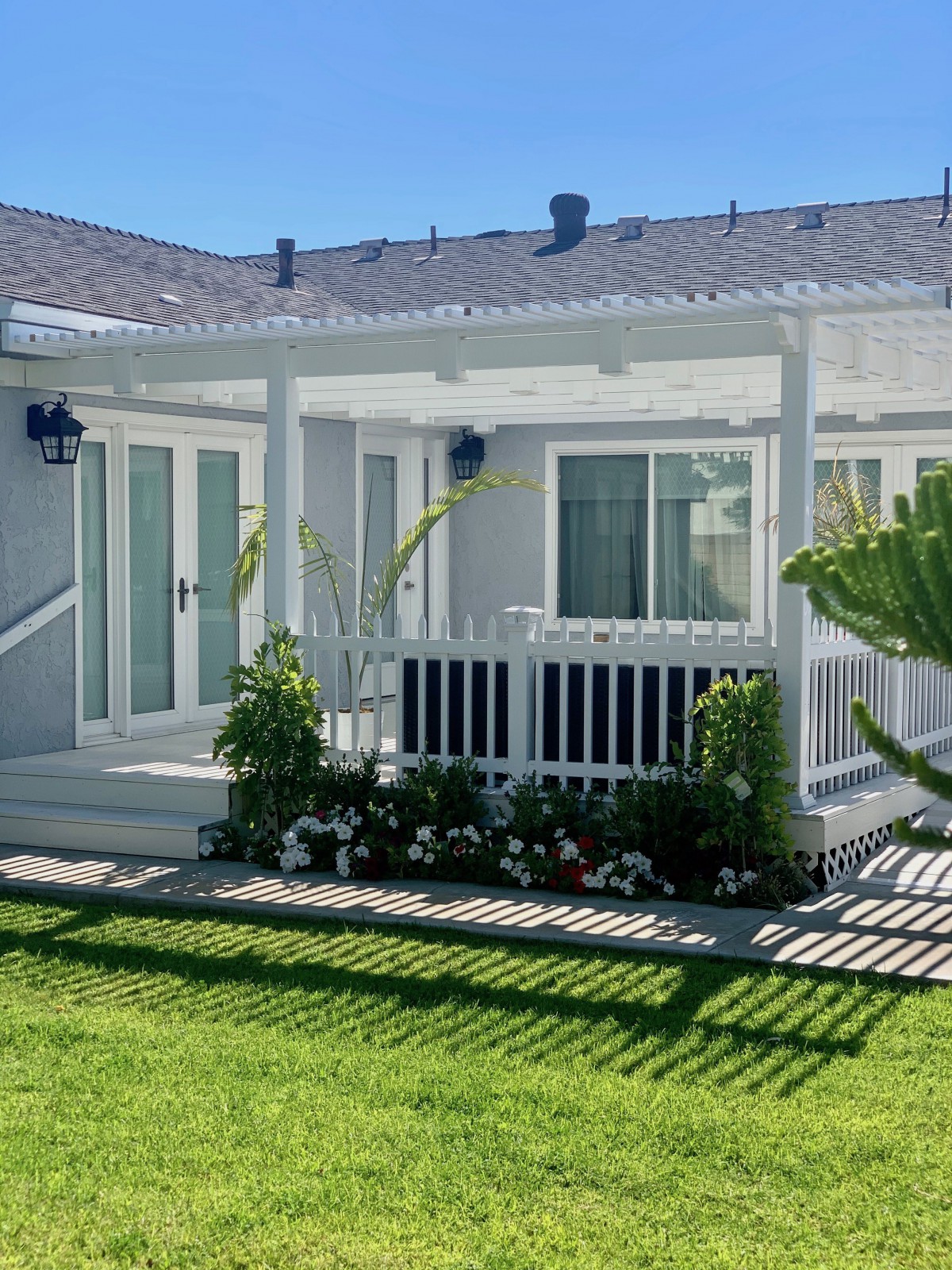 A cozy backyard patio with a pergola and well-maintained landscaping.