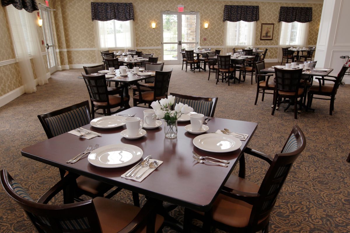 An elegantly set dining area with neatly arranged tables and chairs, ready for guests.