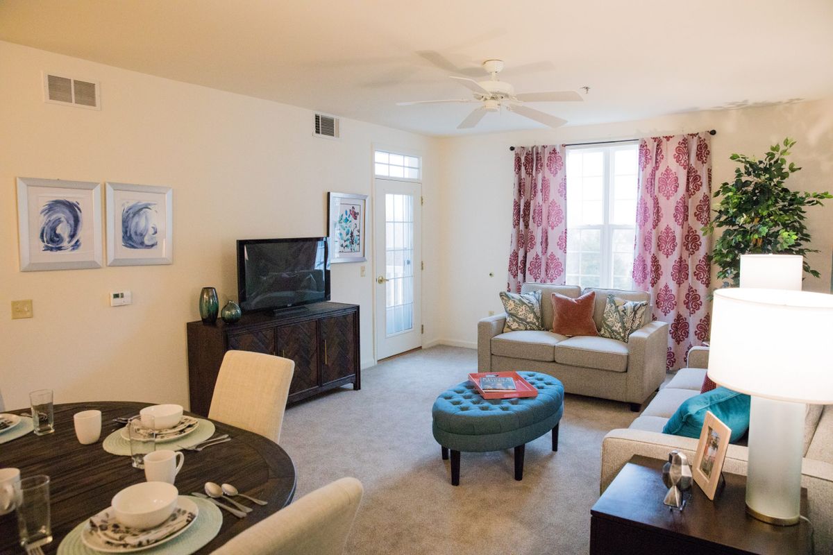 A cozy living room with a sofa, TV, and dining area.