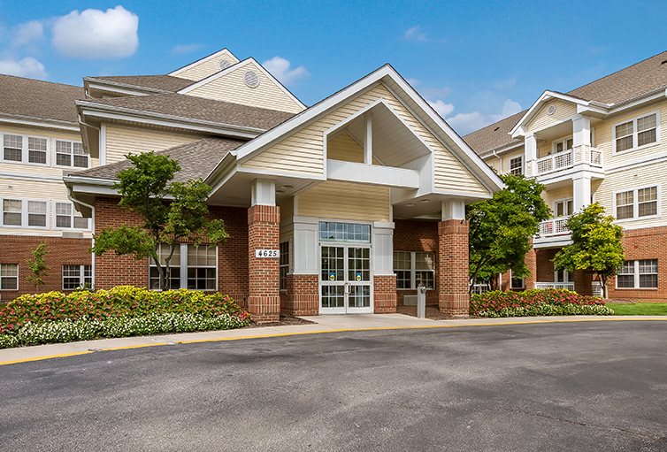 A residential building with a brick facade and landscaped entrance.