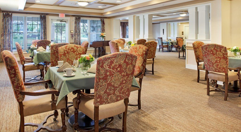 An elegantly decorated dining room featuring floral-patterned chairs and neatly set tables.