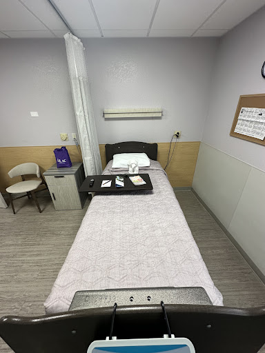A clean and organized hospital room with a bed and medical equipment.