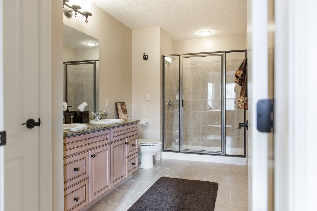 A modern bathroom featuring a large shower, vanity with sink, and a mirror.