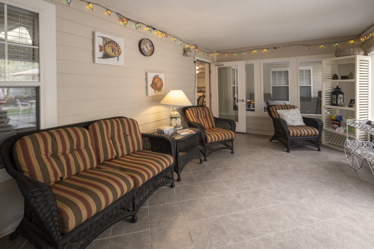 A cozy living room with striped sofas, a lamp, and decorative wall art.