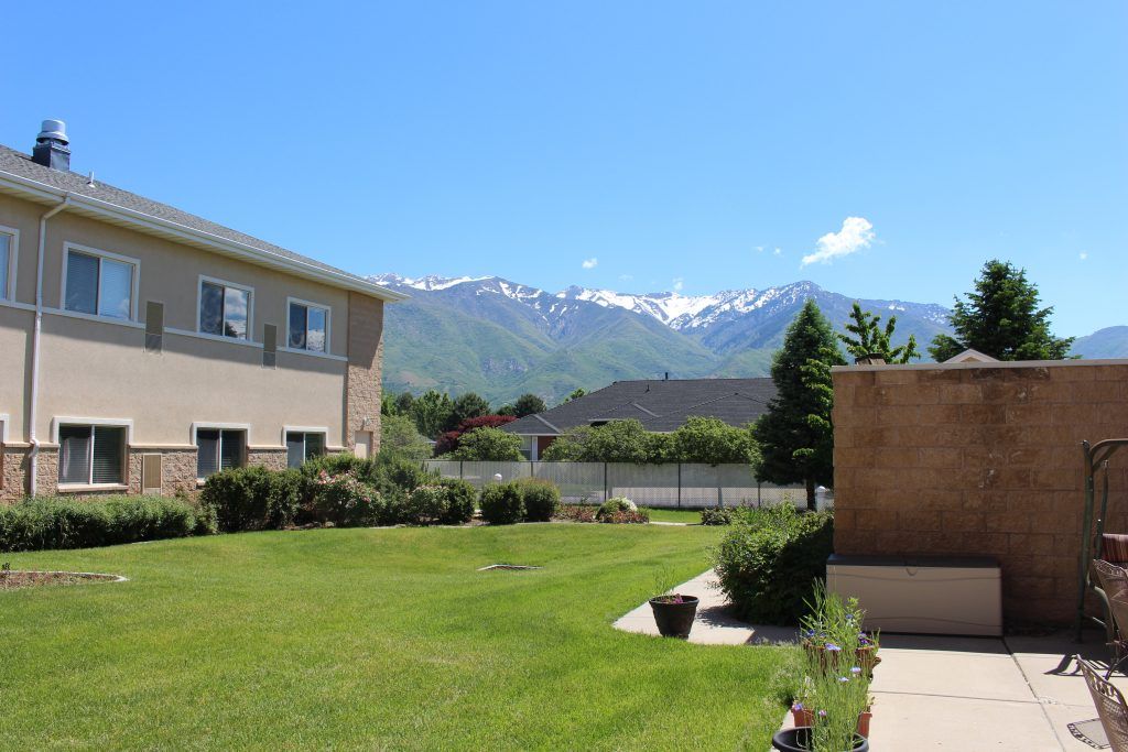 A serene view of a residential area with mountains in the background under a clear blue sky.