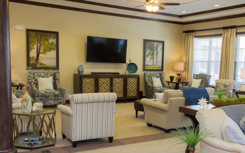 A cozy and well-decorated living room with elegant furniture and a mounted television.