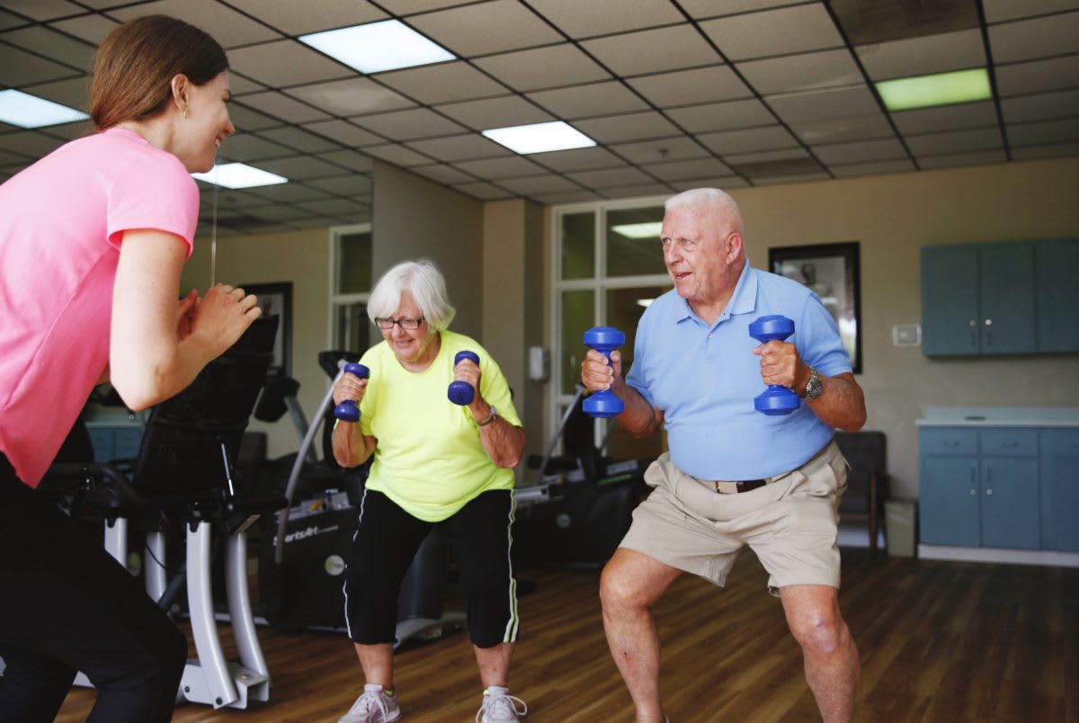 Elderly individuals engaging in a group workout session with dumbbells.