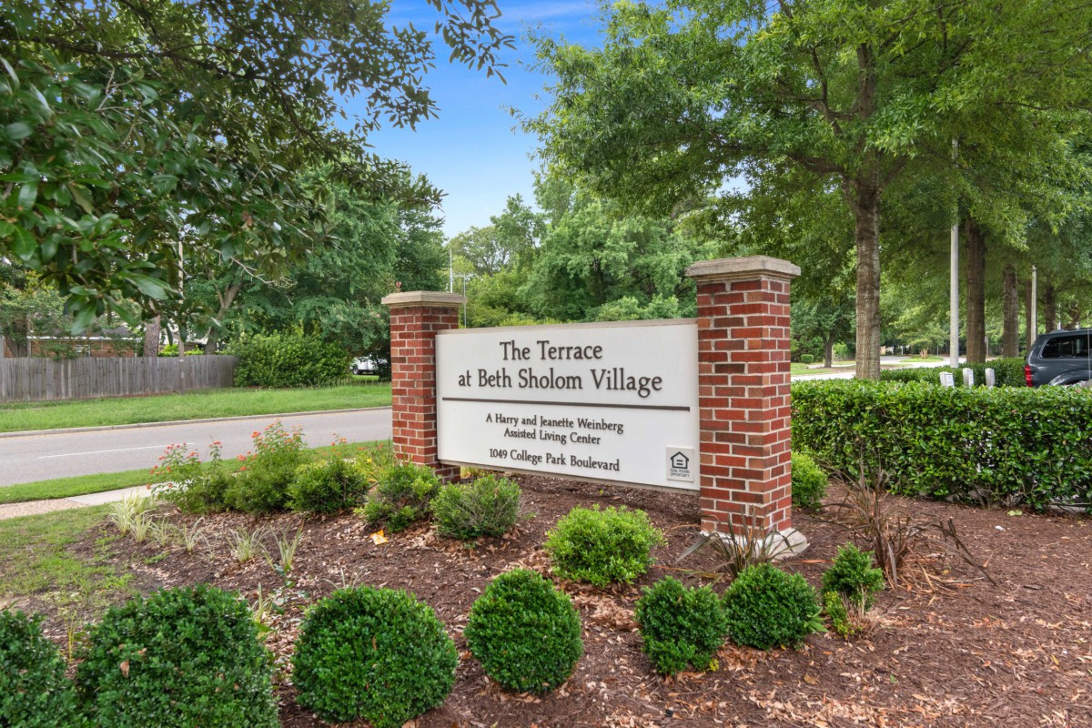 Entrance sign for The Terraces at Beth Sholom Village surrounded by greenery.