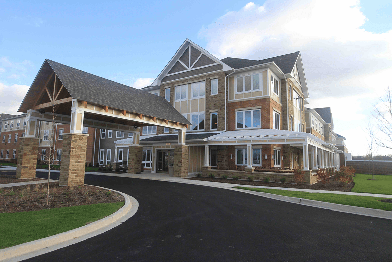 A modern residential building with a driveway and landscaped exterior.
