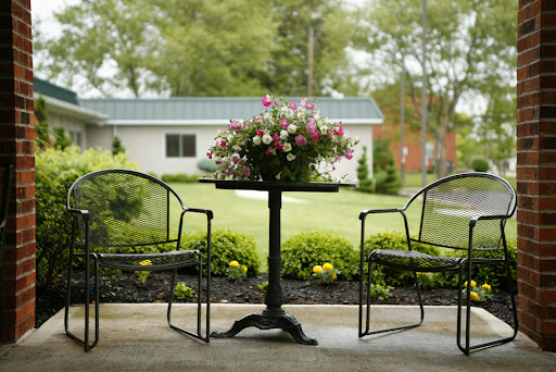 A serene outdoor seating area adorned with a flower arrangement, inviting moments of relaxation in nature.