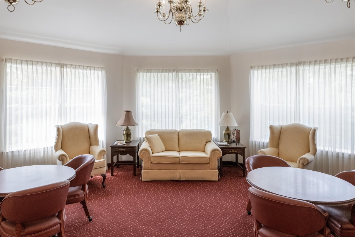 A cozy living room with classic furniture and a chandelier.