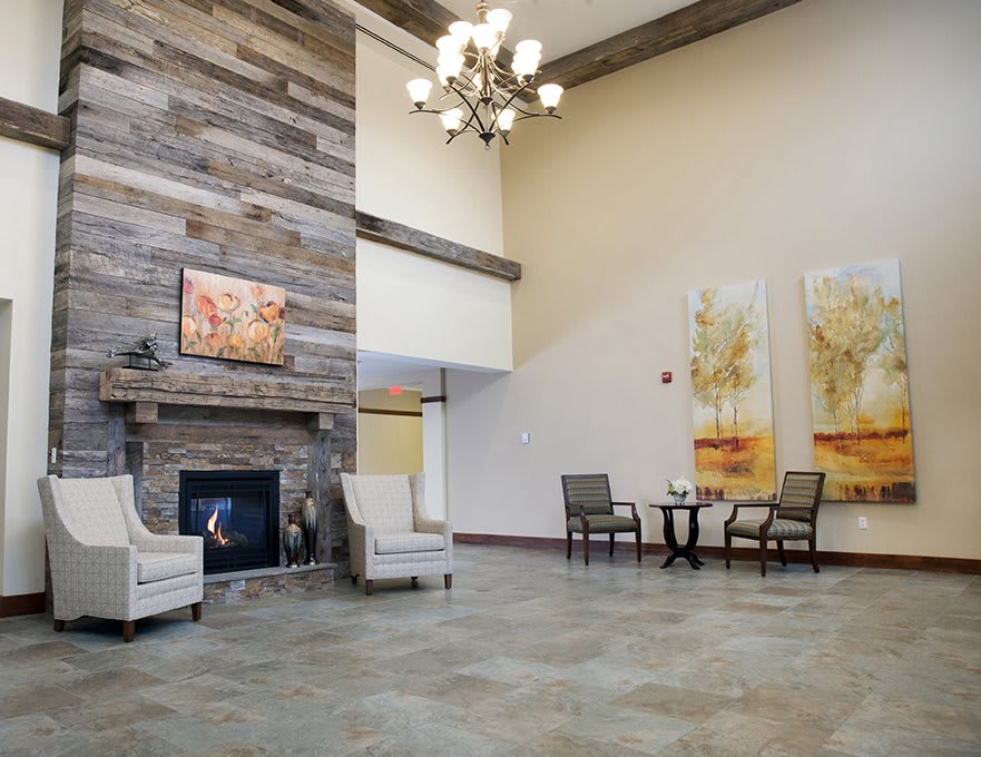 A modern lobby with a fireplace, seating area, and artwork on the walls.