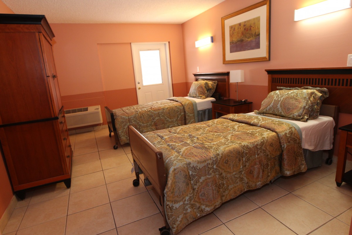 A cozy hotel room featuring twin beds and warm decor.