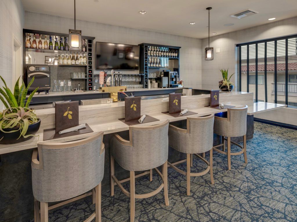 A modern bar area with stylish seating and pendant lighting.