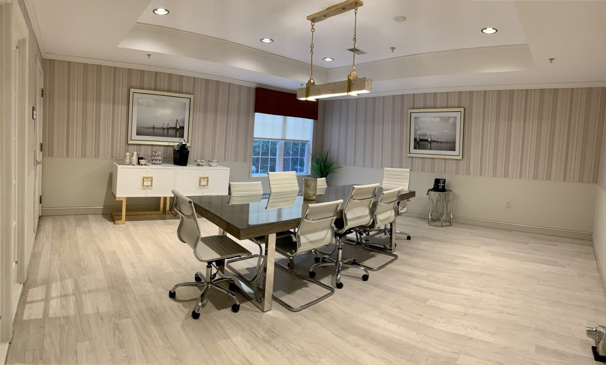 A modern conference room with a large meeting table and sleek chairs, complemented by stylish lighting and wall art.