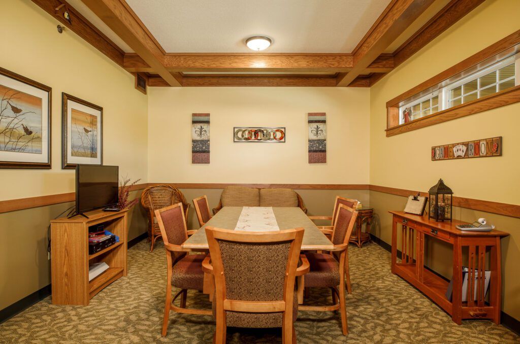 A cozy dining room with wooden table and chairs, surrounded by warm decor and soft lighting.
