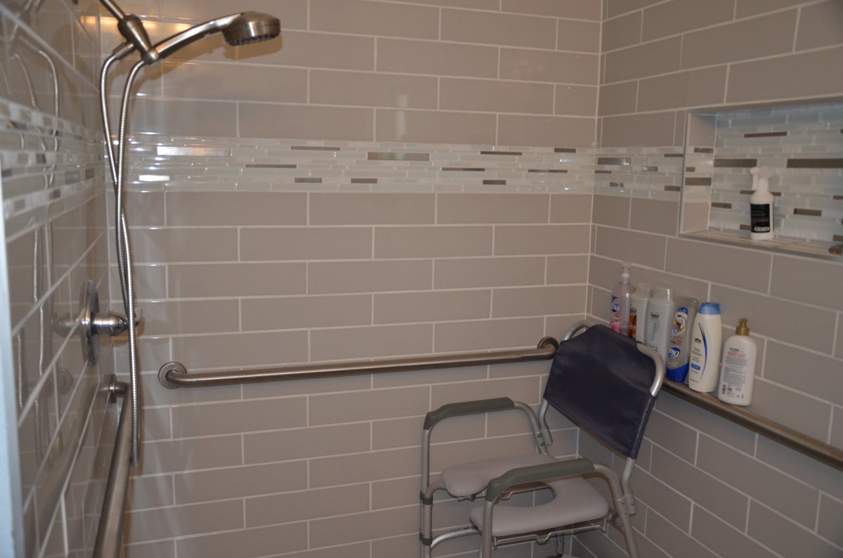 Accessible bathroom with a shower chair and grab bar.