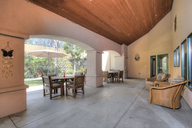 A spacious outdoor patio with seating and a garden view.