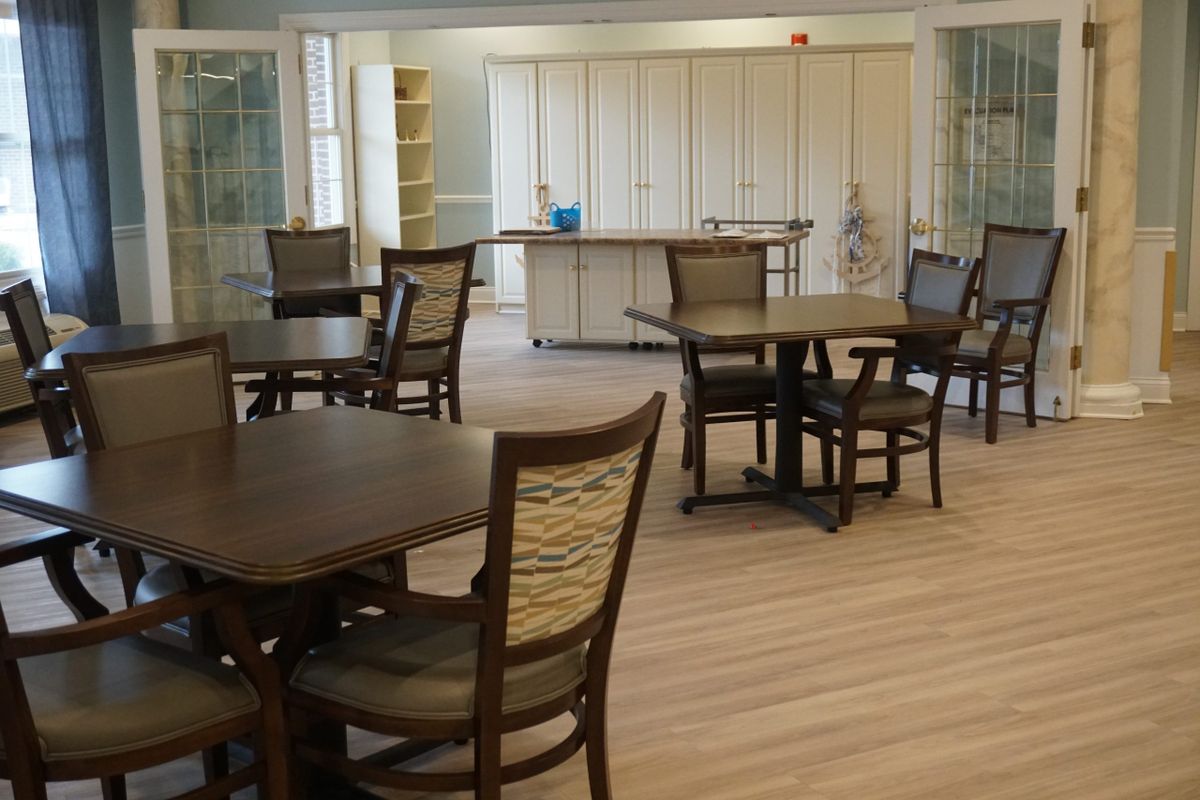 A cozy dining area with several tables and chairs arranged on a wooden floor.