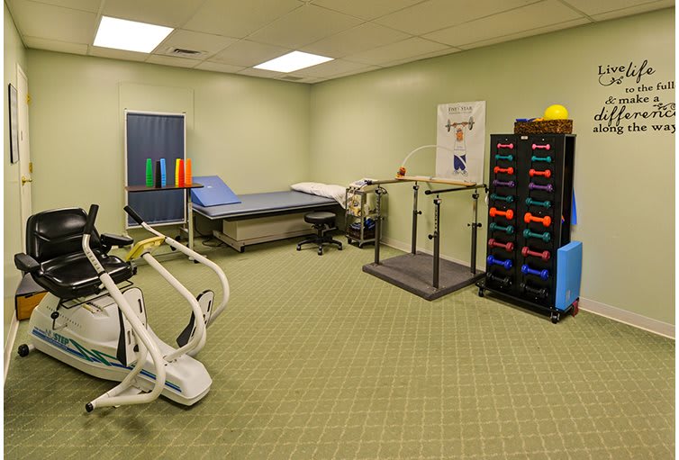A physical therapy room equipped with exercise machines and rehabilitation tools.