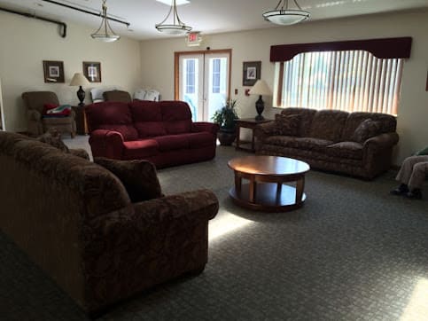 A cozy living room with several sofas and a coffee table arranged in a circular layout.
