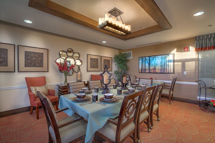 A beautifully decorated dining room with an elegant table setting and modern artwork on the walls.
