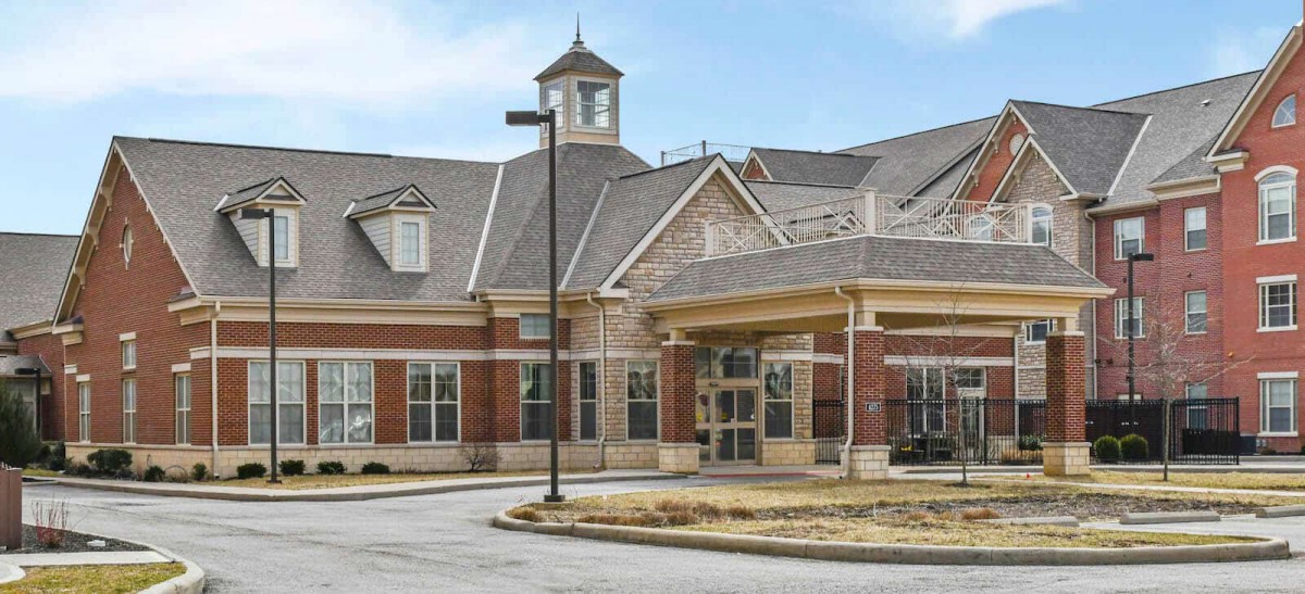 A brick building with a cupola and large windows at the entrance.