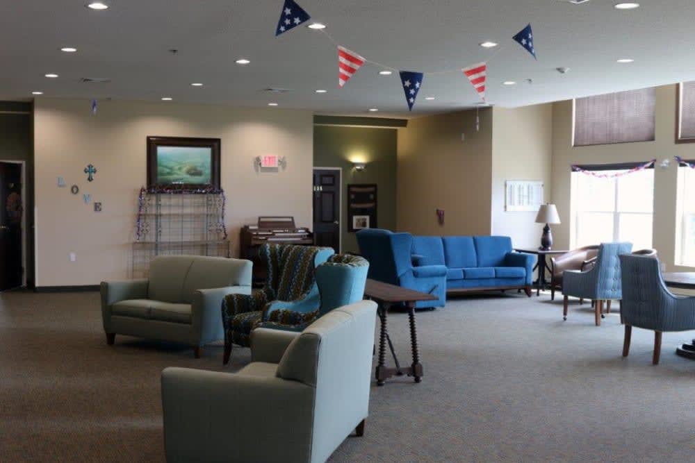 A cozy lobby area with sofas, armchairs, and decorative flags hanging from the ceiling.