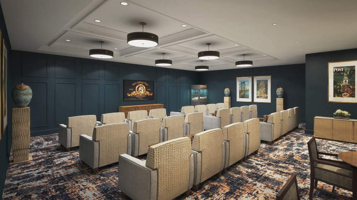 A modern conference room with rows of seating, a large screen at the front, and stylish lighting fixtures.